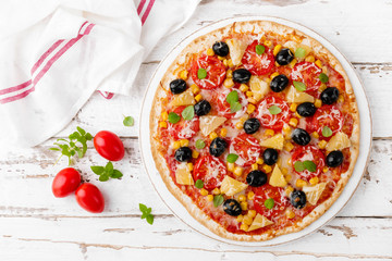 Pizza with tomatoes, mozzarella cheese, olives, corn and basil. Traditional italian cuisine. Top view