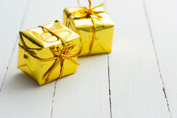 Golden gift box on white wood