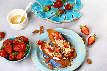 Obraz premium Italian bruschetta with strawberry, nuts and cheese camembert on wooden rustic background. Dieting and weight loss concept. Flat lay, close up