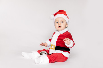 Cute little toddler girl wearing Santa costume photographed over white background.