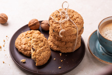 Cup of coffee, oatmeal cookies, coffee maker on white wooden background. Bright morning