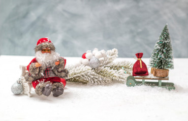 Christmas attributes: Santa Claus, a tree on a sleigh and a bag of toys. 