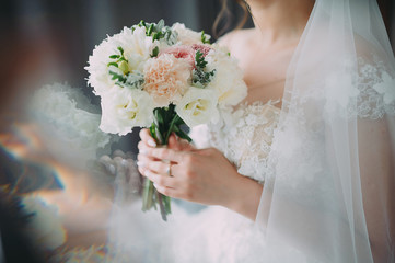 A beautiful bride is holding a wedding bouquet