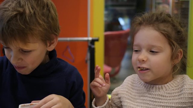 Fast food restaurant children boy and girl funny eat feed each other french fries potatoes