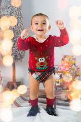 Merry Christmas. Happy little child is wearing a funny Christmas sweater at home.