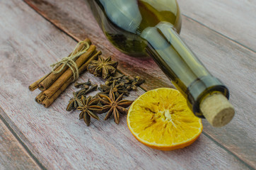 Hot mulled wine drink with lemon, apple, cinnamon, anise and other spices in a glass cup between...