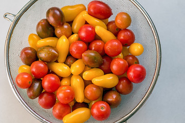 Colorful, healthy foods. Clean, fresh, washed Colorful Cherry tomatoes in a colander. Drops of water on vegetables. Important to wash vegetables before eating concept.