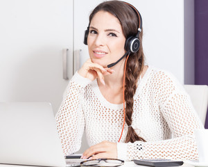 young woman with headset sitting at desk e-learning support call-center home office
