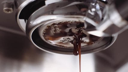 Pouring coffee stream from professional machine in cup. Barista man making double espresso, using filter holder. Flowing fresh ground coffee. Drinking roasted black coffee in the morning. - Powered by Adobe