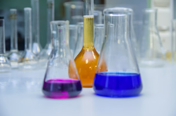 Laboratory glassware with multi-colored liquid on table. Chemical analysis
