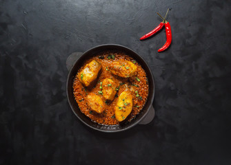 Top view of spicy and hot Bengali fish curry. Indian food. Fish curry with red chili, curry leaf, coconut milk. Asian cuisine.
