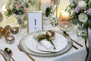 Piękna złota zastawa stołowa na stole bankietowym, ślub, wesele.