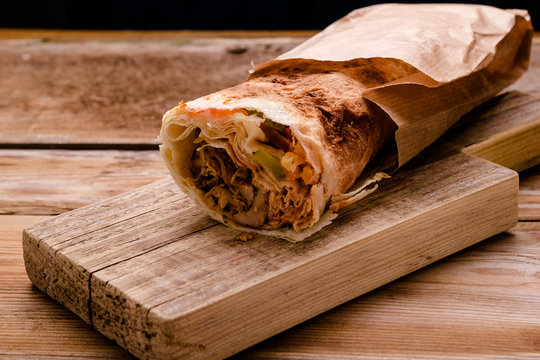 Doner Kebab Gyros Shawarma Beef Roll In Pitta Bread Wrap Sandwich On Wooden Background. Copy Space