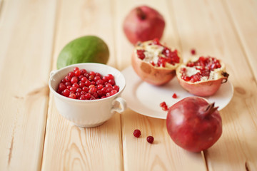 pomegranate, grapes, lime and cranberries on a wooden surface