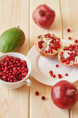 pomegranate, grapes, lime and cranberries on a wooden surface