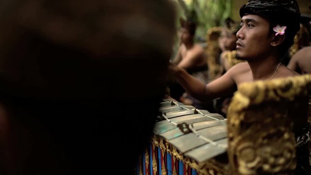 Asian Balinese musician gamelan group playing in traditional dress in a ceremonial celebration performance Indonesia South East Asia