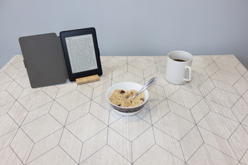 Electronic book and a cup of coffee on the table