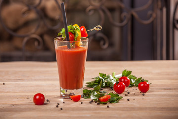 glass of tomato juice and tomatoes on wooden table