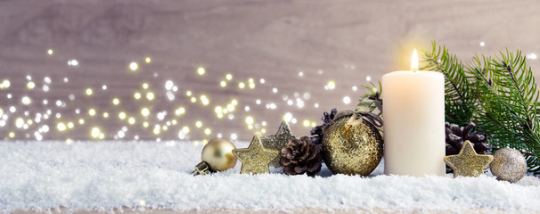 Christmas background with Advent candle and golden decoration.