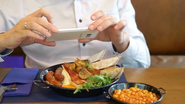 Man taking picture of English breakfast in 4k slow motion 60fps
