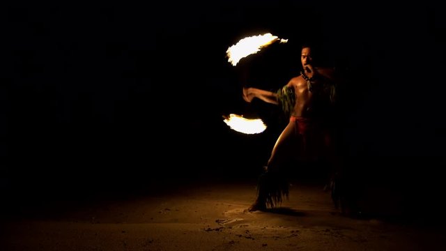 Male Fire dancer with illuminated spinning flaming torch performing the Art of Fire dancing a traditional culture in French Polynesia South Pacific