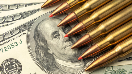 on the banknotes of dollars are fighting bullets close-up. Concept of war and money