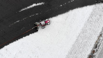 Farm tractor spreading liquid manure in snow covered field.