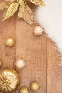 Christmas background. Gold Christmas balls on a wooden background. Winter holidays concept. Top view with copy space, vertical image