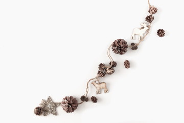 Christmas minimal composition. Garland made of twigs and cones, decorations on white background. Christmas, winter, new year concept. Flat lay, top view, copy space