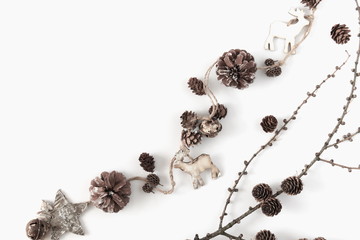 Christmas minimal composition. Garland made of twigs and cones, decorations on white background. Christmas, winter, new year concept. Flat lay, top view, copy space