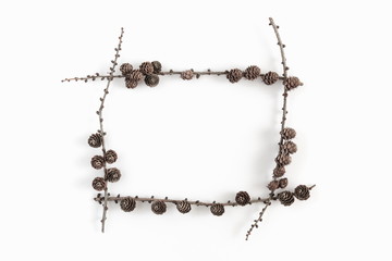 Naklejka premium Christmas minimal composition. Frame made of twigs and cones on white background. Christmas, New Year, winter concept. Flat lay, top view, copy space