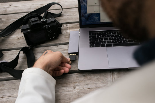 Workflow or creative process of freelance photographer or director. Export or transfer data files, images and videos from camera to laptop through multifunctional adaptor or cardreader