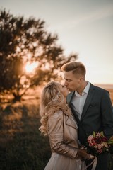 Stylish wedding photo shoot in nature at sunset.