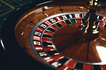 Roulette table in casino, with many games and slots, roulette wheel in the foreground. Golden and...