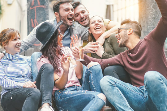 Happy friends doing party drinking champagne at sunset outdoor - Young millennial people having fun celebrating birthday and laughing together - Friendship and youth holidays lifestyle concept