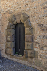 Rustic old wooden double door in stone wall