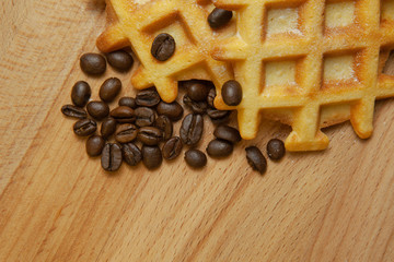 Tasty fresh Belgian wafers, grain coffee on a wooden background, copy space