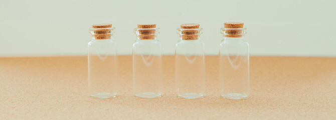 Empty little bottles with cork stopper on white background, close-up