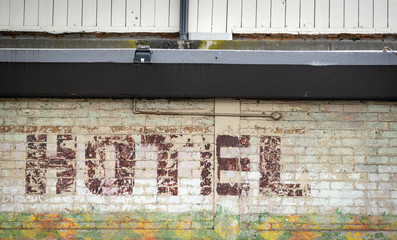 An old and faded painted Hotel sign on a brick wall