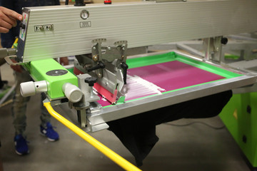 screen printer flooding a pink screen