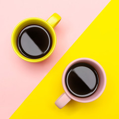 Flat lay of a two coffee cups with pink and yellow