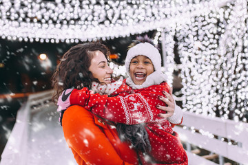 Little black girl enjoying in ice skating with her mother.