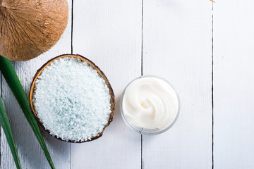 coconut moisturizer cream and bath salt , on white wood table
