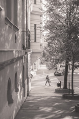 View of a street in Budapest, Hungary with a soft light. A young woman crossing the street. 