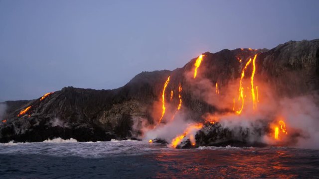 Big Island red hot lava pouring into the Pacific ocean from erupting Kilauea volcano Hawaii seen before dawn USA 