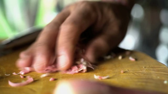 Cutting a selection of healthy nutritious vegetables on wooden chopping board with Balinese Blakas in Indonesia