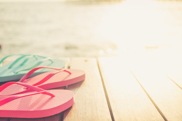 Flip flops at the wooden pier during sunset. Luxury vacation resort. Holiday getaway concept