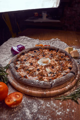 Pizza on wooden background with tomatoes, mushrooms,  basil and mozzarella cheese, close up top view