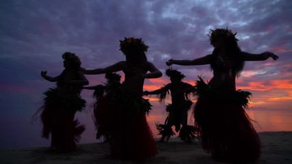 Young males and females in a group of Tahitian hula dancers performing at sunset on the beach barefoot in traditional costume Tahiti French Polynesia South Pacific - Powered by Adobe