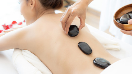 beautiful and healthy young woman  during a back stone therapy massage in spa salon